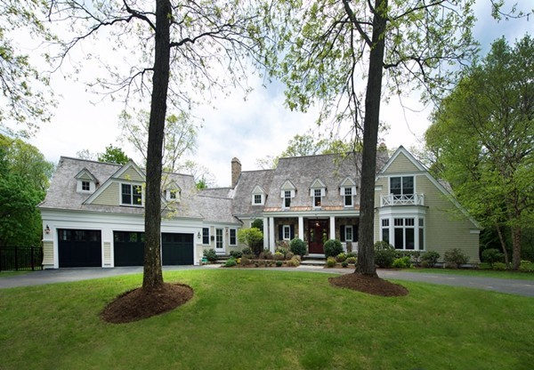 a aerial view of a house next to a yard with big trees