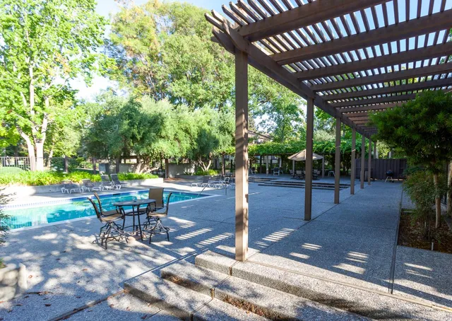 a view of a patio with table and chairs with wooden floor and fence