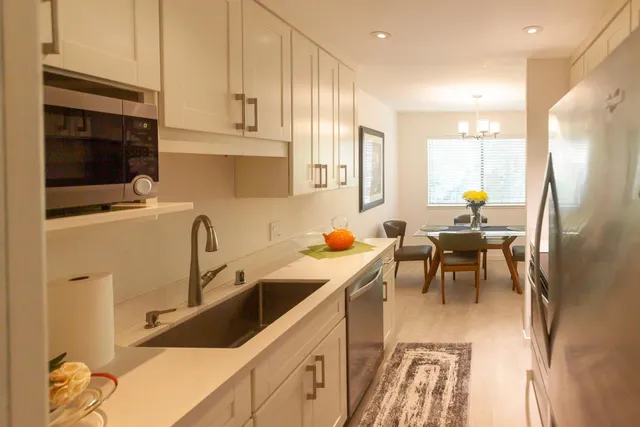a kitchen with stainless steel appliances granite countertop sink refrigerator and cabinets