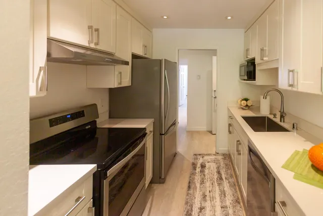 a kitchen with a sink stove and refrigerator