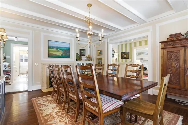 a dining room with furniture a chandelier and wooden floor