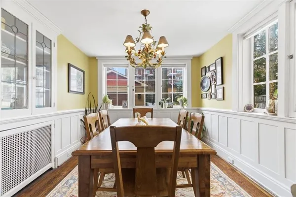a view of a dining room with furniture a chandelier and wooden floor