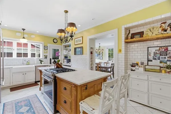 a very nice looking kitchen with granite countertop a stove oven and white cabinets