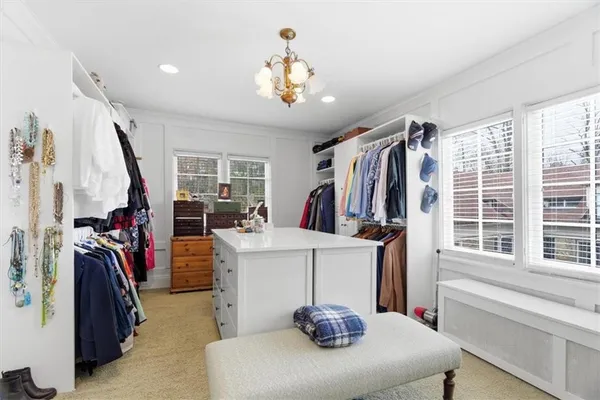 a view of a walk in closet with clothes and shoes