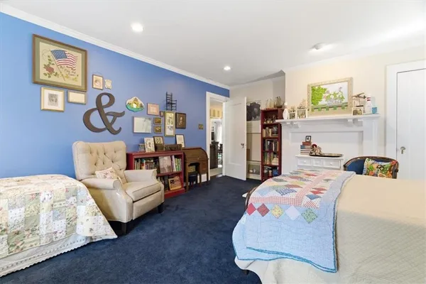 a bedroom with a bed couch and a large window