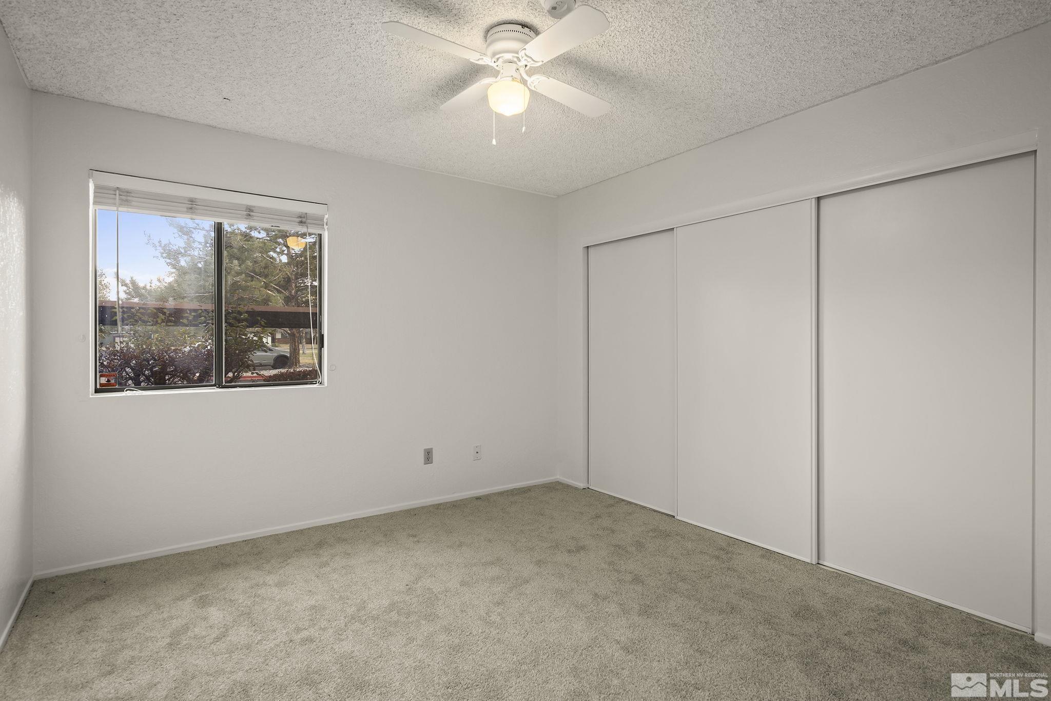 4893 Reggie Road Reno, NV 89502 - Photo 11 of 27 an empty room with a window and a ceiling fan