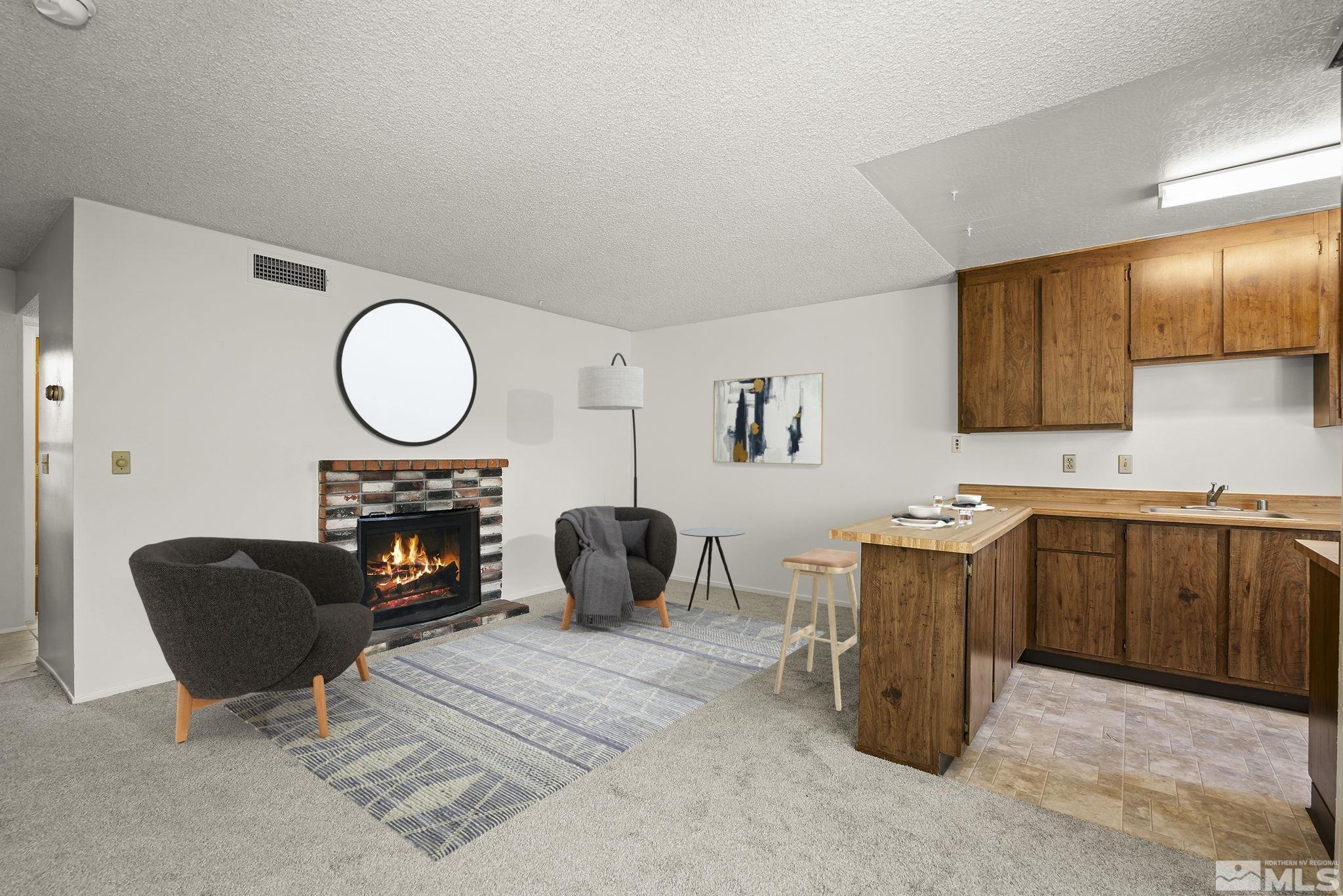 4893 Reggie Road Reno, NV 89502 - Photo 3 of 27 a living room with furniture a mirror kitchen view and a fireplace