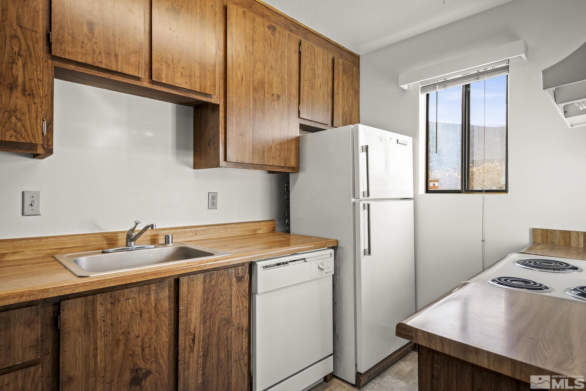 4893 Reggie Road Reno, NV 89502 - Photo 8 of 27 a utility room with closet a stove and a window