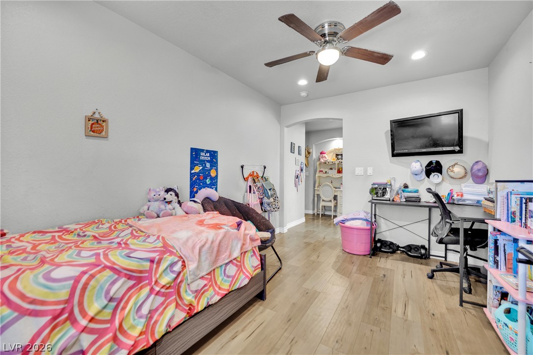 420 North Racetrack Road Henderson, NV 89015 - Photo 27 of 52 Hardwood floors and a ceiling fan create a comfortable atmosphere in this inviting bedroom.