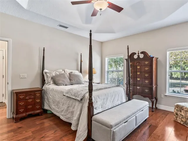 a reading room with furniture ceiling fan and a window