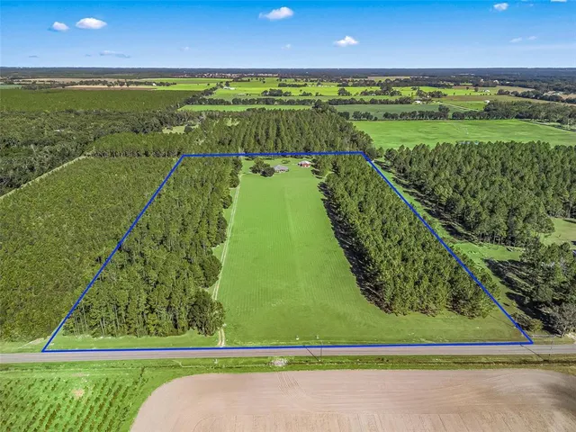 a living room with furniture kitchen view and a wooden floor