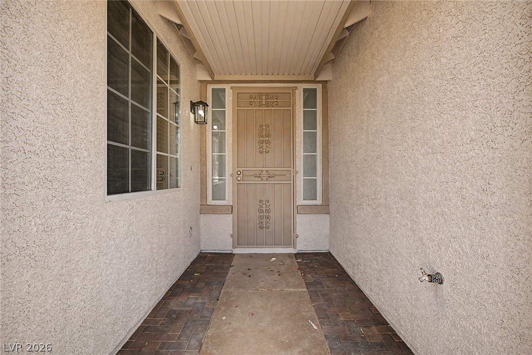835 Entrada Ridge Avenue Henderson, NV 89012 - Photo 2 of 34 A welcoming entry path of brick pavers leads to a decorative front door, framed by sidelight windows.