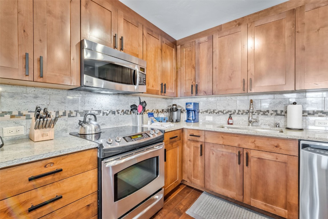 1175 Bangtail Way, Unit 4120 Steamboat Springs, CO 80487 - Photo 13 of 43 a kitchen with granite countertop white cabinets and white appliances