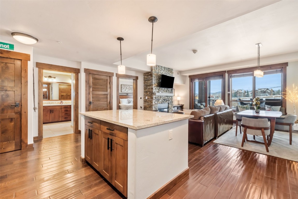 1175 Bangtail Way, Unit 4120 Steamboat Springs, CO 80487 - Photo 16 of 43 a kitchen with kitchen island granite countertop a stove and a living room view