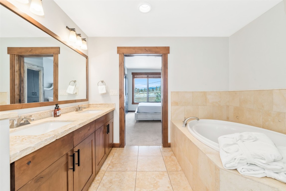 1175 Bangtail Way, Unit 4120 Steamboat Springs, CO 80487 - Photo 26 of 43 a spacious bathroom with a tub sink and mirror