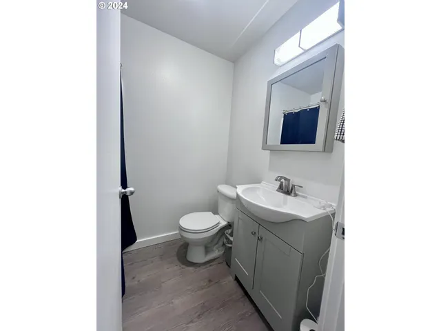 a bathroom with a toilet a sink and mirror