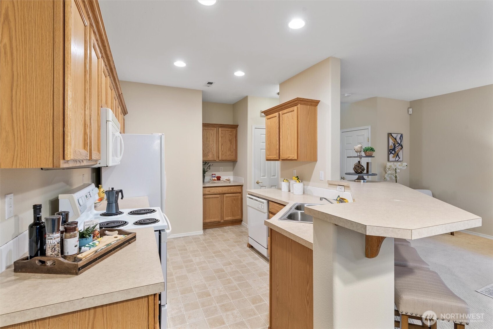 3030 Southeast 12th Street, Unit 1077 Renton, WA 98058 - Photo 14 of 36 a kitchen with a sink a stove a refrigerator and cabinets