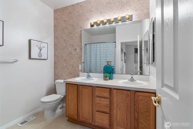 a bathroom with a granite countertop toilet sink and mirror