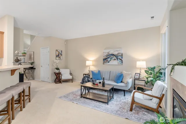 a living room with furniture and a potted plant on table