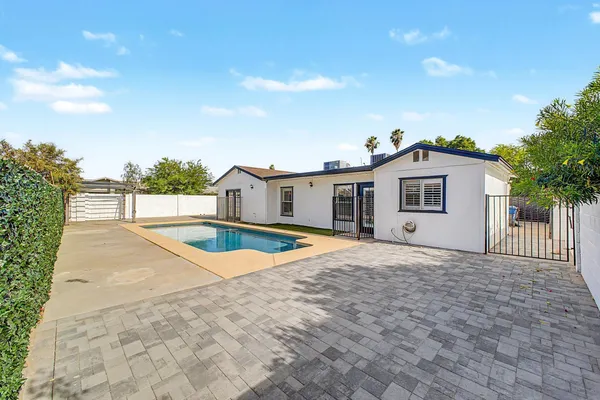 a view of a house with pool and a yard