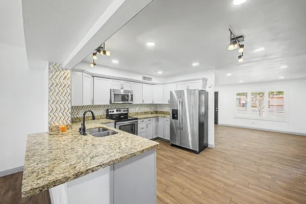 a kitchen with refrigerator and chairs