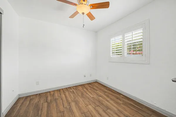 an empty room with a window and a ceiling fan