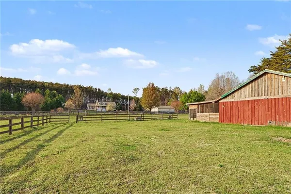 a view of big yard with wooden fence