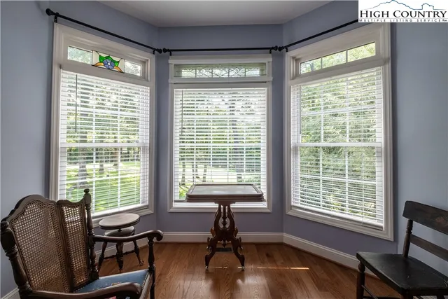 a view of a livingroom with lounge chair and a large window
