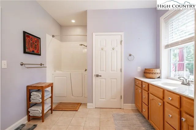 a spacious bathroom with a mirror sink and shower