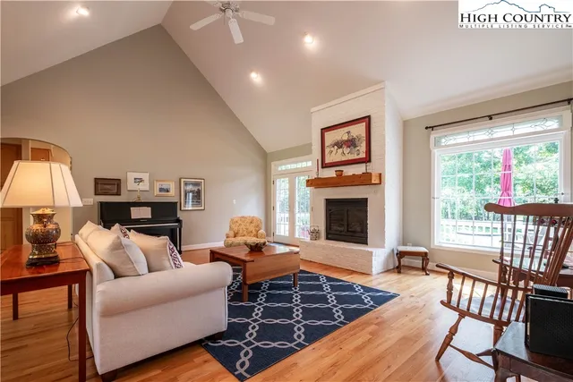 a living room with furniture a large window and a fireplace