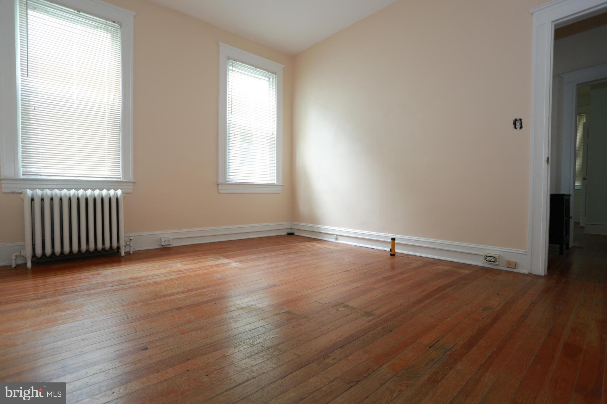 2317 Monticello Road Baltimore, MD 21216 - Photo 12 of 30 an empty room with wooden floor and windows