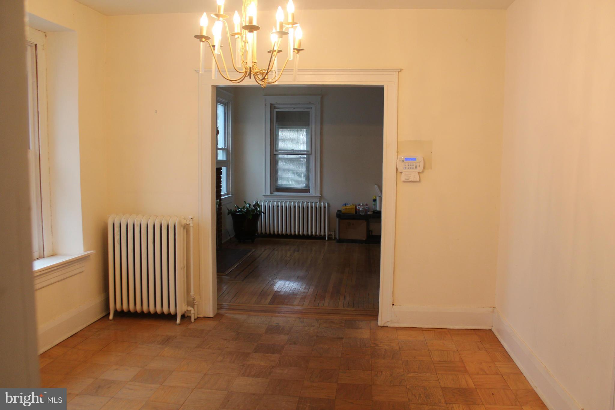 2317 Monticello Road Baltimore, MD 21216 - Photo 3 of 30 a view of a hallway with wooden floor and a dining room
