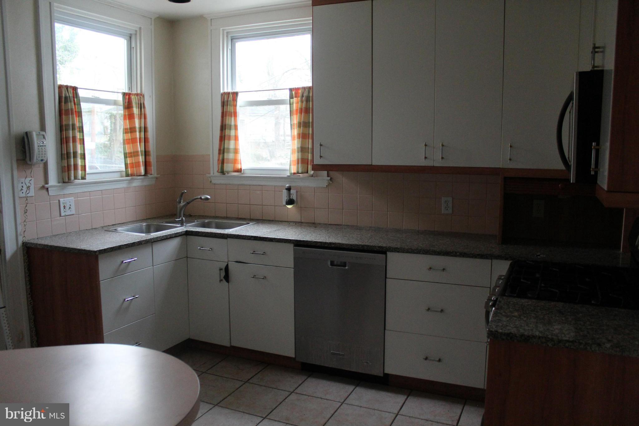 2317 Monticello Road Baltimore, MD 21216 - Photo 7 of 30 a kitchen with sink a window and cabinets