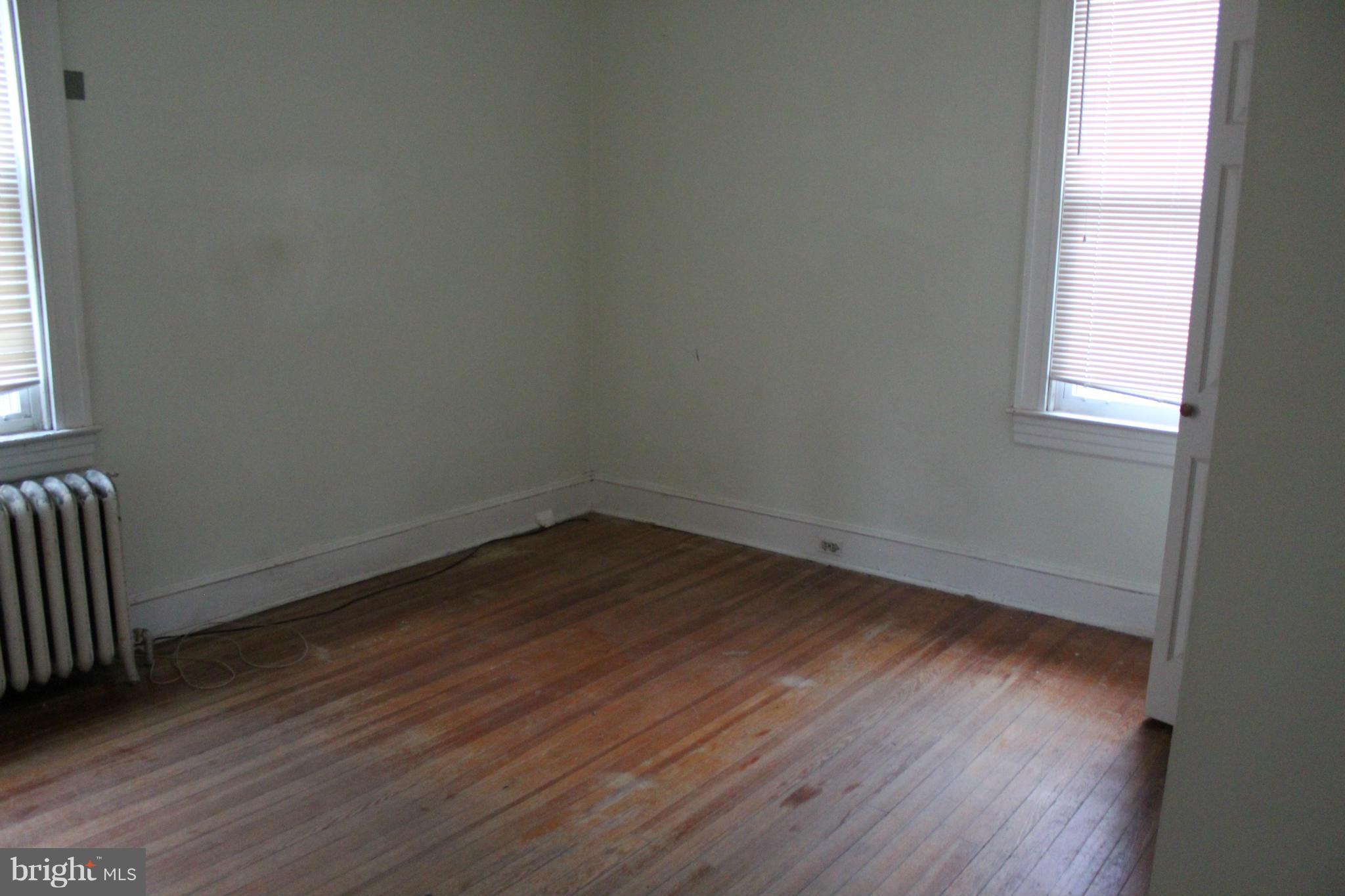 2317 Monticello Road Baltimore, MD 21216 - Photo 9 of 30 an empty room with wooden floor and windows
