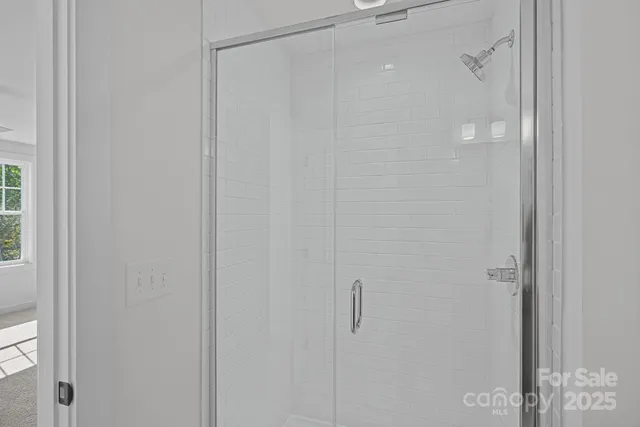a view of an empty room with wooden floor and a ceiling fan