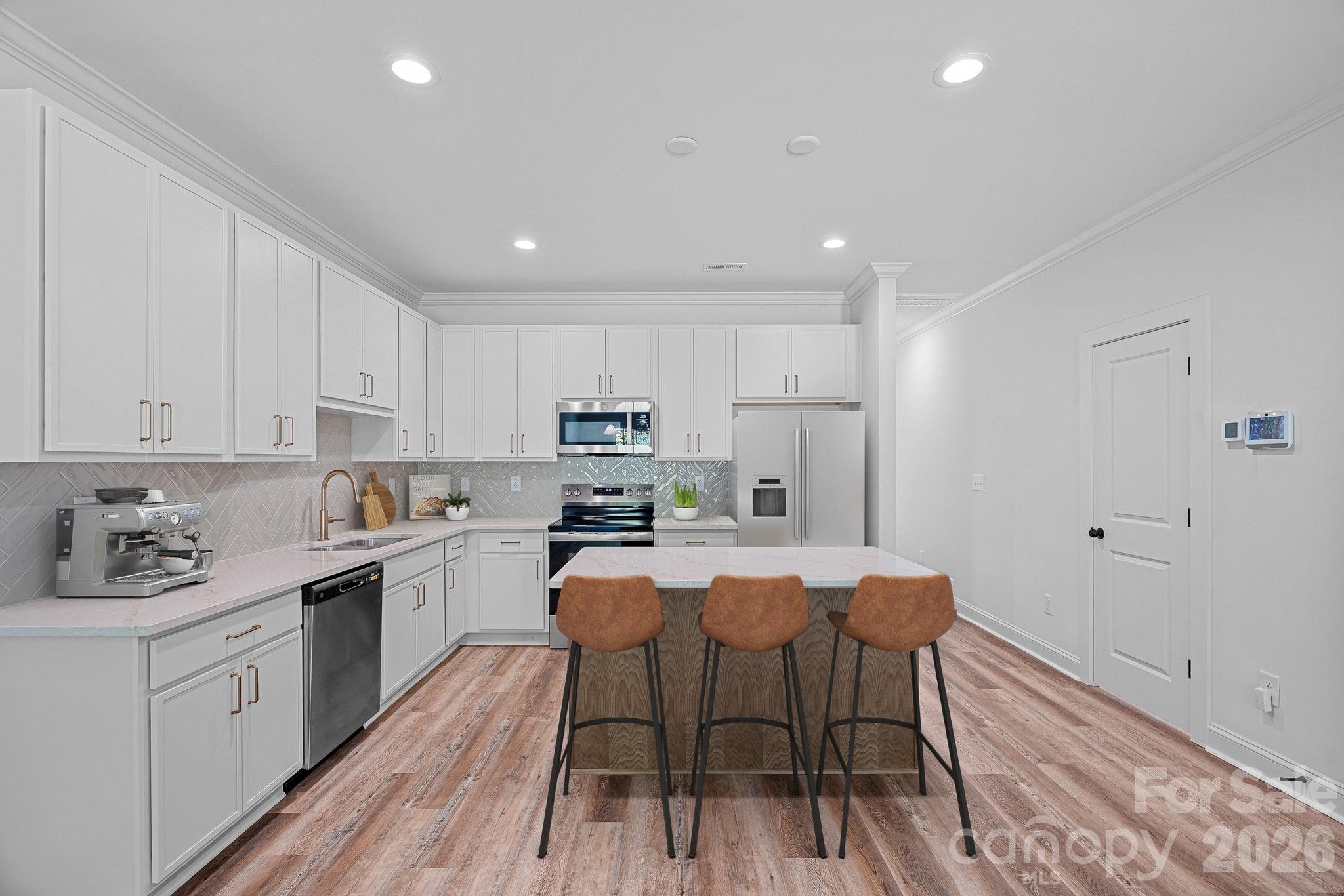 4015 Sofley Road Charlotte, NC 28206 - Photo 5 of 41 a kitchen with stainless steel appliances a white table chairs refrigerator and sink