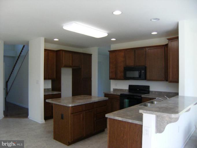 783 Rivanna Run Falling Waters, WV 25419 - Photo 10 of 30 a kitchen with stainless steel appliances granite countertop a stove and a refrigerator