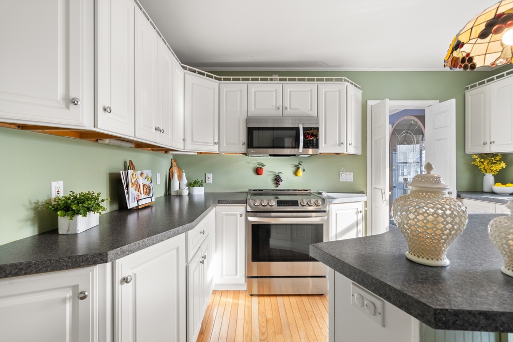 26-28 Alton Street Arlington, MA 02474 - Photo 9 of 41 a kitchen with granite countertop a sink stainless steel appliances and white cabinets