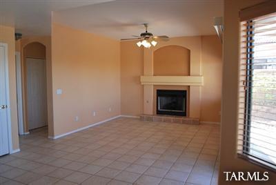 1118 South Riparian Avenue Tucson, AZ 85748 - Photo 9 of 13 an empty room with a fireplace chandelier and a window