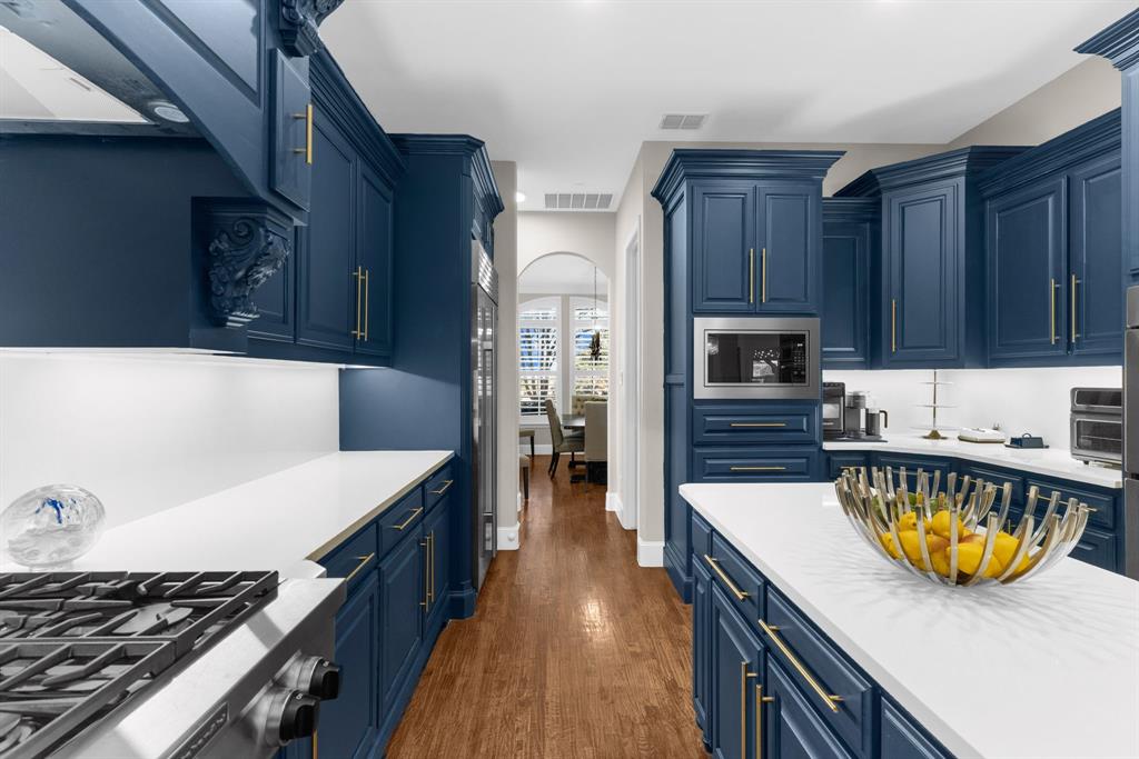 2257 Hermitage Drive Allen, TX 75013 - Photo 12 of 40 a kitchen with stainless steel appliances granite countertop a lot of counter space and wooden floors