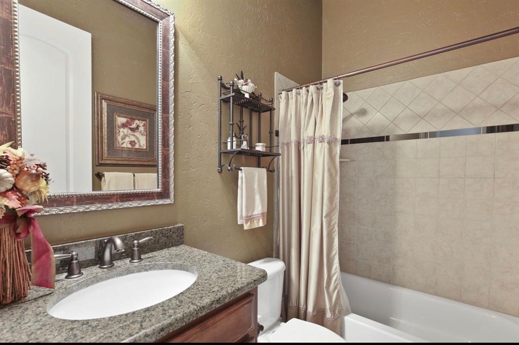 2257 Hermitage Drive Allen, TX 75013 - Photo 29 of 40 a bathroom with a granite countertop sink toilet and shower