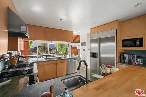 a bedroom with a bed and a dresser next to a window