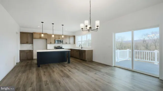 a large kitchen with kitchen island a large counter space a sink appliances and cabinets