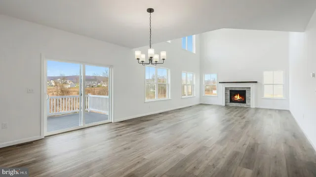 a view of a livingroom with wooden floor a fireplace and windows