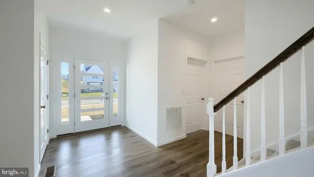 a view of a hallway with wooden floor and entryway