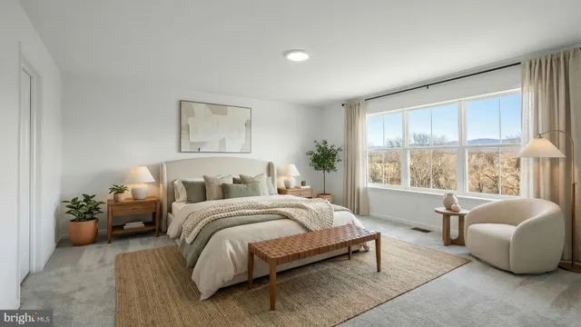 a spacious bedroom with a bed and glass window