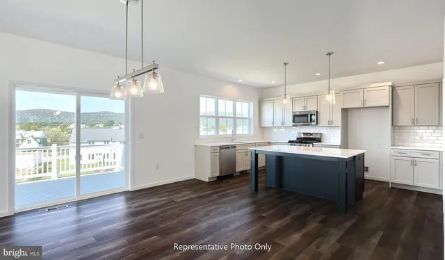 a kitchen with sink a stove and wooden floor