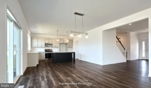 a large kitchen with white cabinets and stainless steel appliances