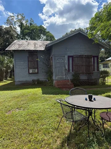 a backyard of a house with table and chairs