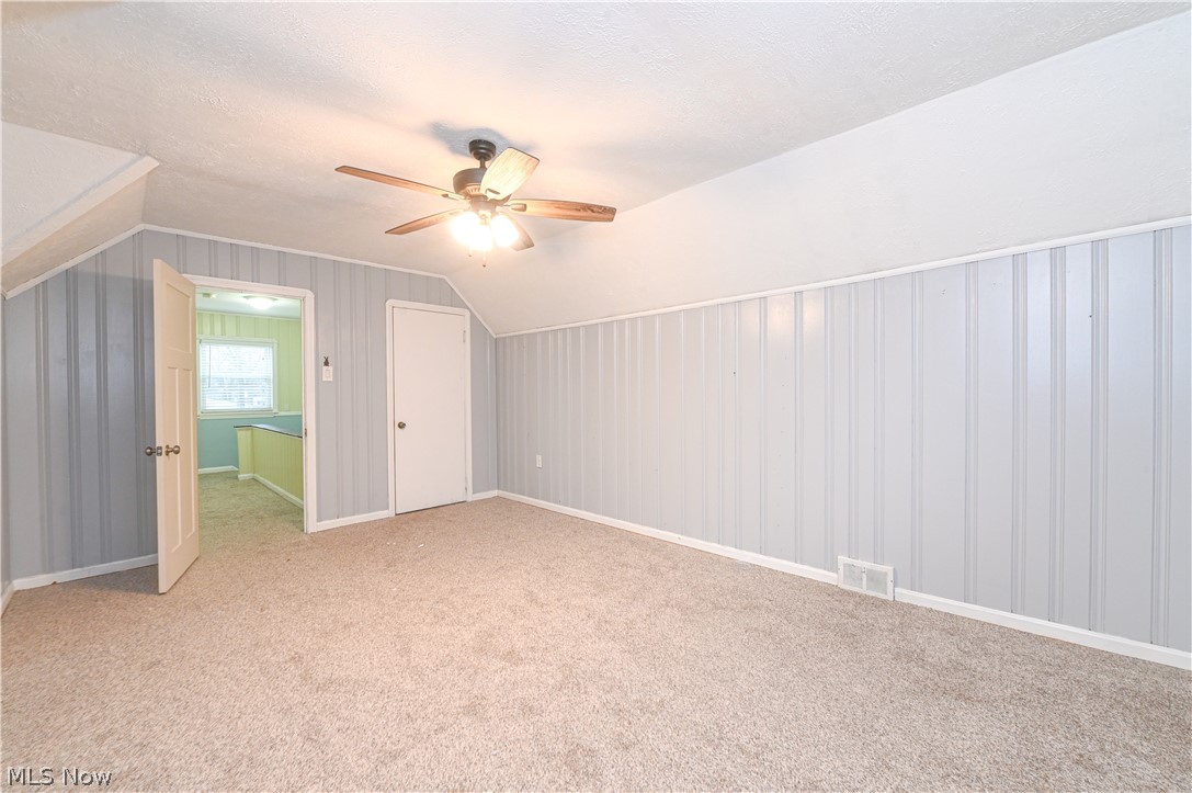 8301 Ackley Road Parma, OH 44129 - Photo 30 of 47 Bonus room with ceiling fan, a textured ceiling, light colored carpet, and vaulted ceiling